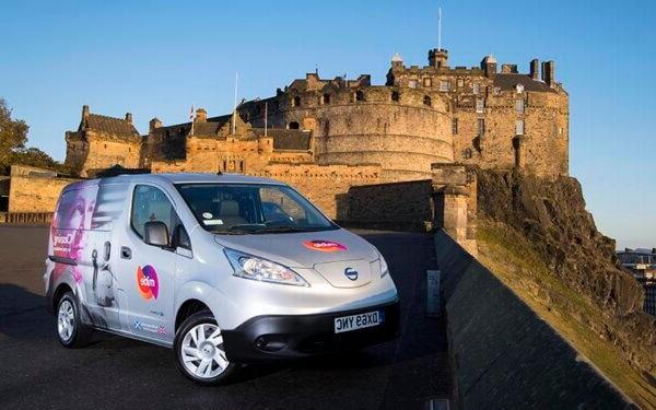 EV银色面包车与米蒂品牌在前景，与爱丁堡城堡在背景